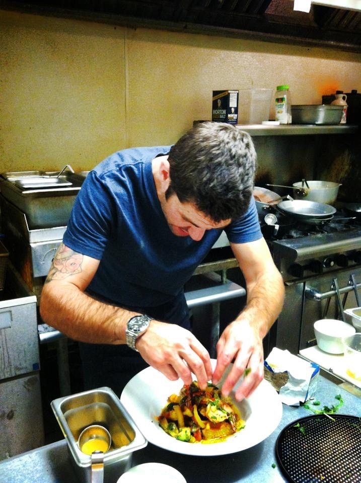 Chef Marc Walden plating a dish in a professional kitchen