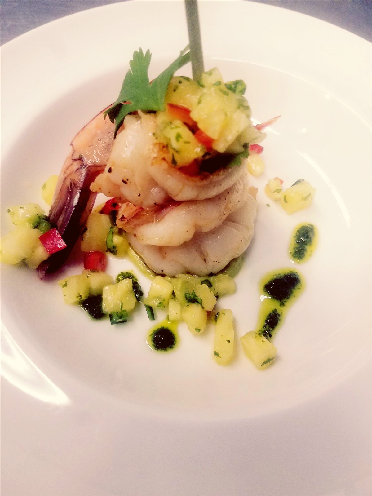 Seared shrimp and fish ceviche stack with pineapple salsa on white plate