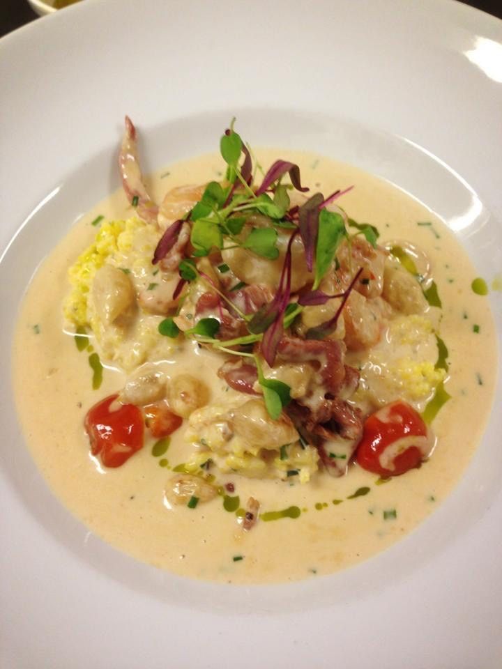Gulf shrimp and oyster grits in cream sauce with cherry tomatoes