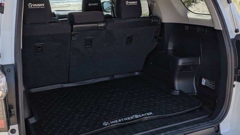 White 2021 Toyota 4Runner SR5 cargo area — Husky WeatherBeater liner with beach access visible in background