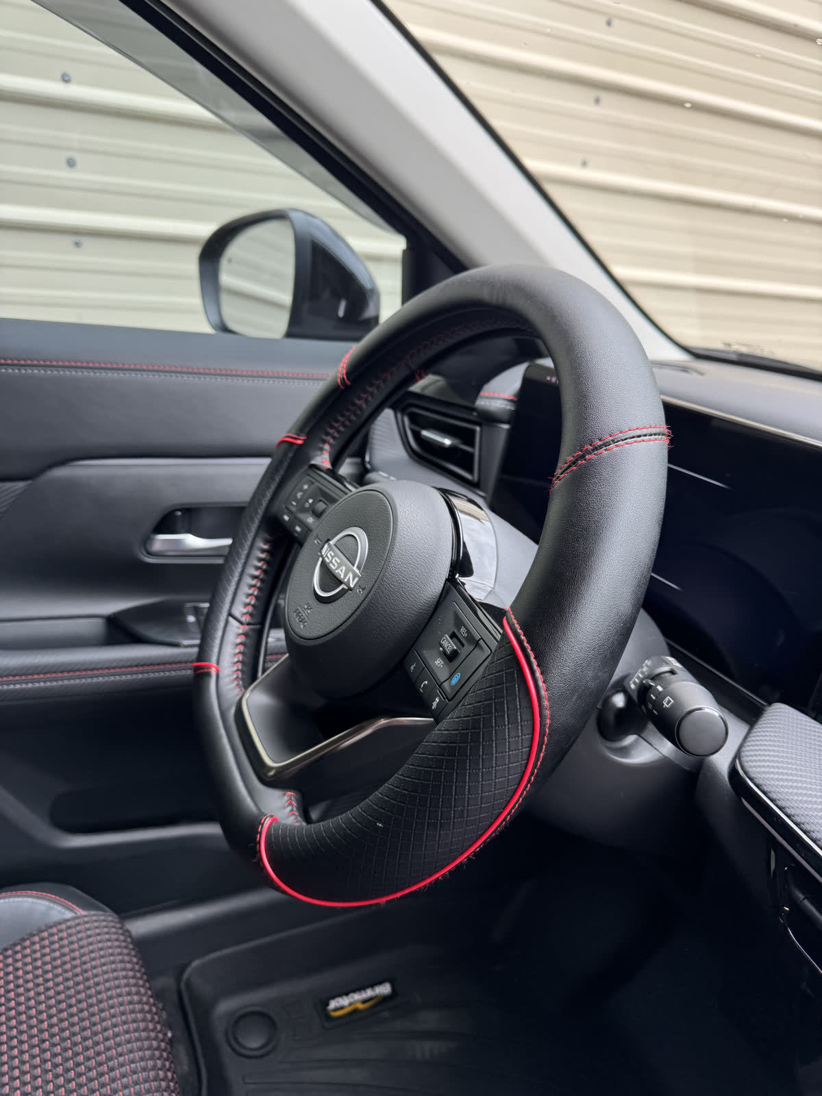 Kicks SR steering wheel — red-stitch leather and controls