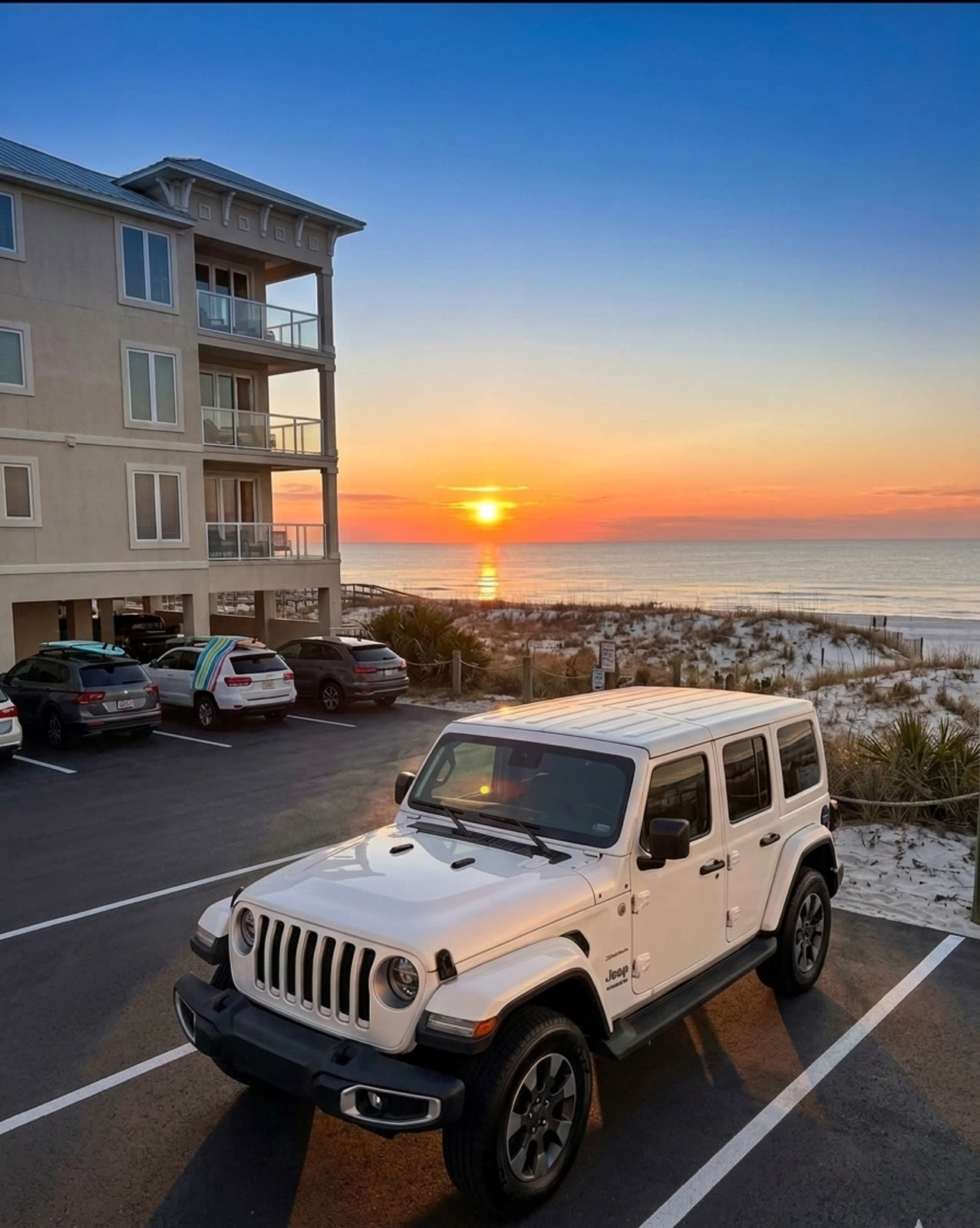White 2025 Jeep Wrangler Sahara parked beachfront at golden hour, Gulf Shores dunes and shoreline