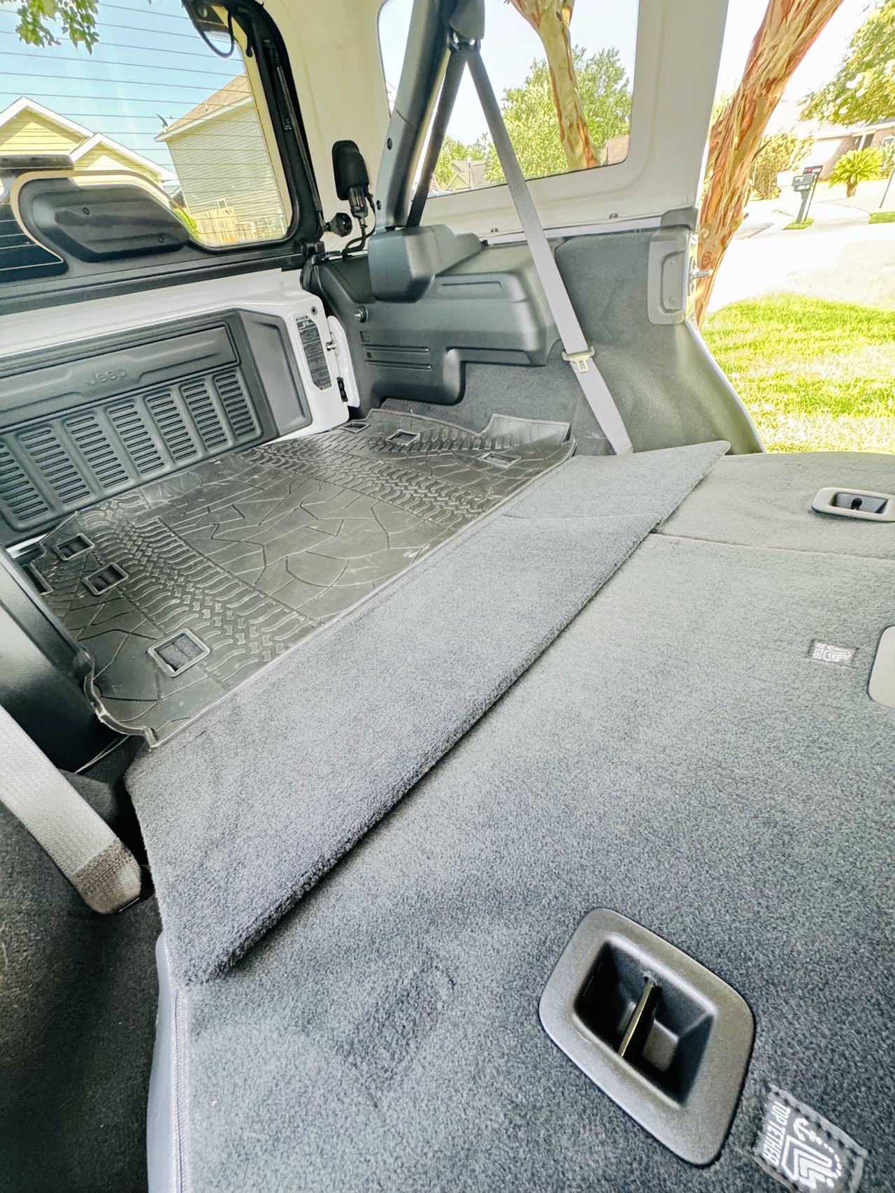 2025 Jeep Wrangler Sahara rear seats folded flat for extra cargo room, ideal for beach gear and luggage